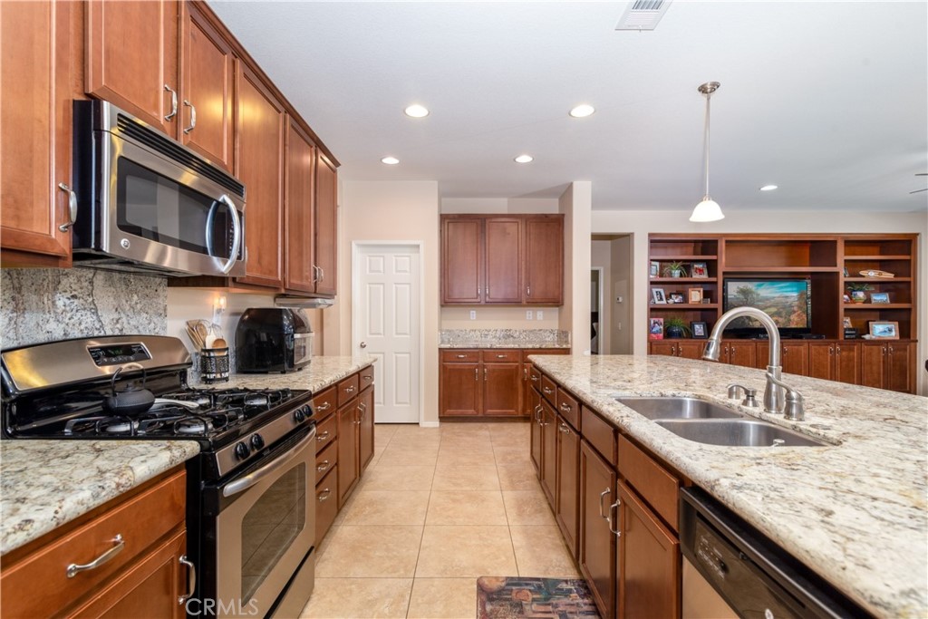 27336 Brandon Lane Temecula, CA 92591 - Photo 11 of 49 a kitchen with stainless steel appliances granite countertop a sink a stove and a microwave