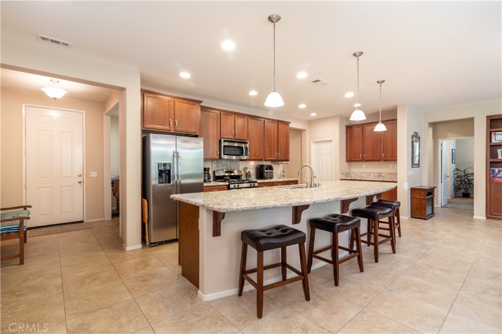 27336 Brandon Lane Temecula, CA 92591 - Photo 6 of 49 a kitchen with stainless steel appliances kitchen island granite countertop a sink and a refrigerator