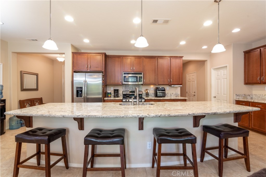 27336 Brandon Lane Temecula, CA 92591 - Photo 8 of 49 a kitchen with stainless steel appliances granite countertop a stove a sink and a refrigerator