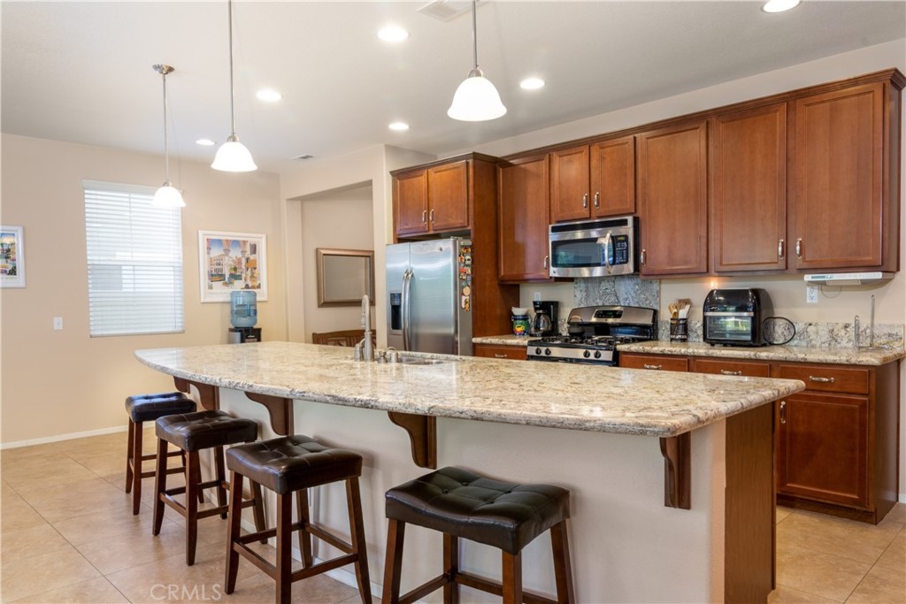 27336 Brandon Lane Temecula, CA 92591 - Photo 9 of 49 a kitchen with stainless steel appliances granite countertop a sink a stove a refrigerator cabinets and chairs