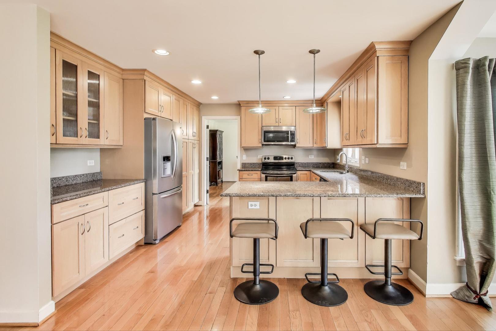 25839 West Sunset Road Barrington, IL 60010 - Photo 12 of 54 a kitchen with stainless steel appliances kitchen island granite countertop a refrigerator and cabinets