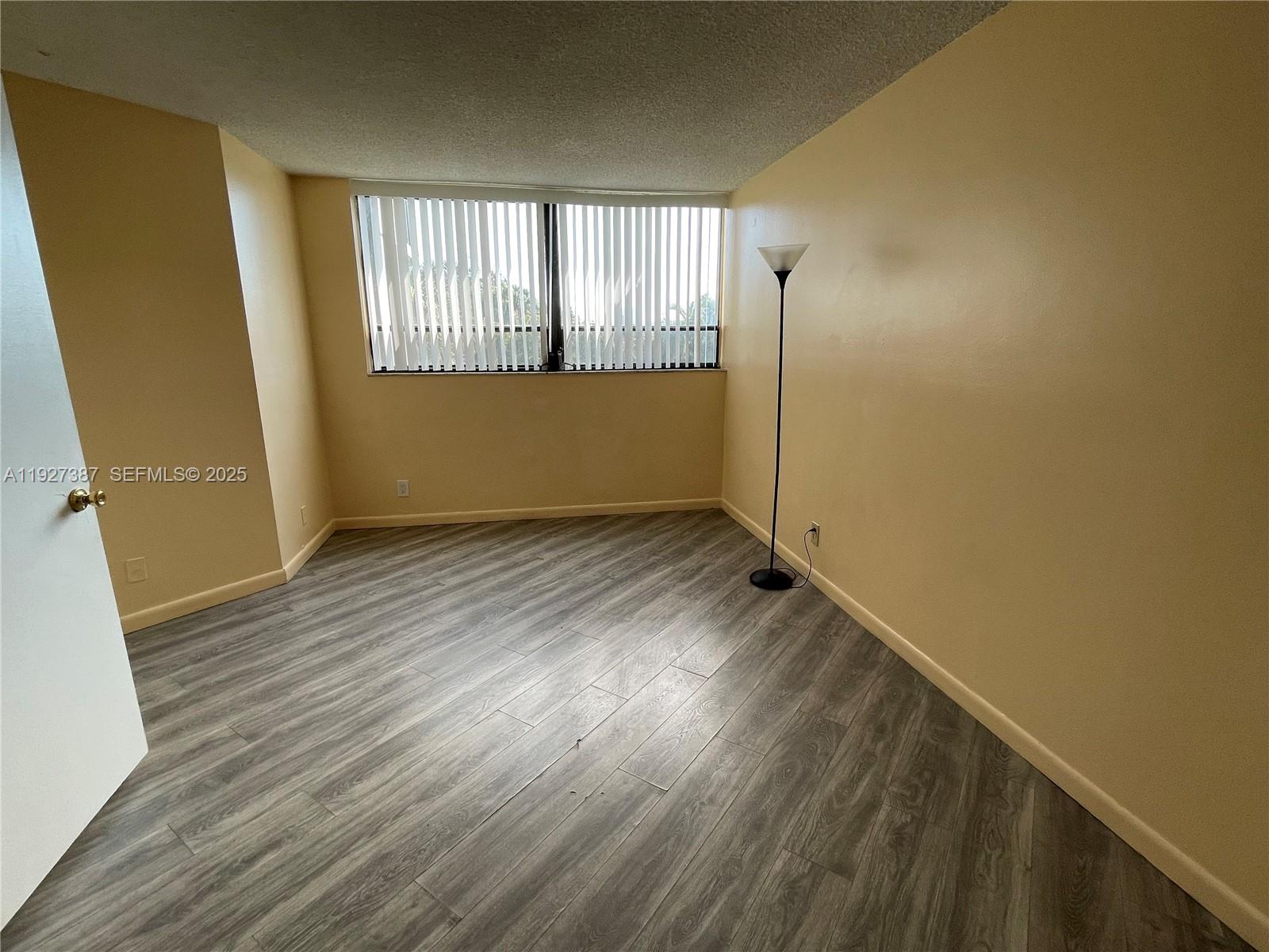 1720 North Congress Avenue, Unit 310 West Palm Beach, FL 33401 - Photo 14 of 18 an empty room with wooden floor and windows