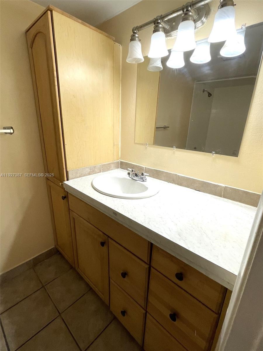 1720 North Congress Avenue, Unit 310 West Palm Beach, FL 33401 - Photo 16 of 18 a bathroom with a sink a vanity and a mirror