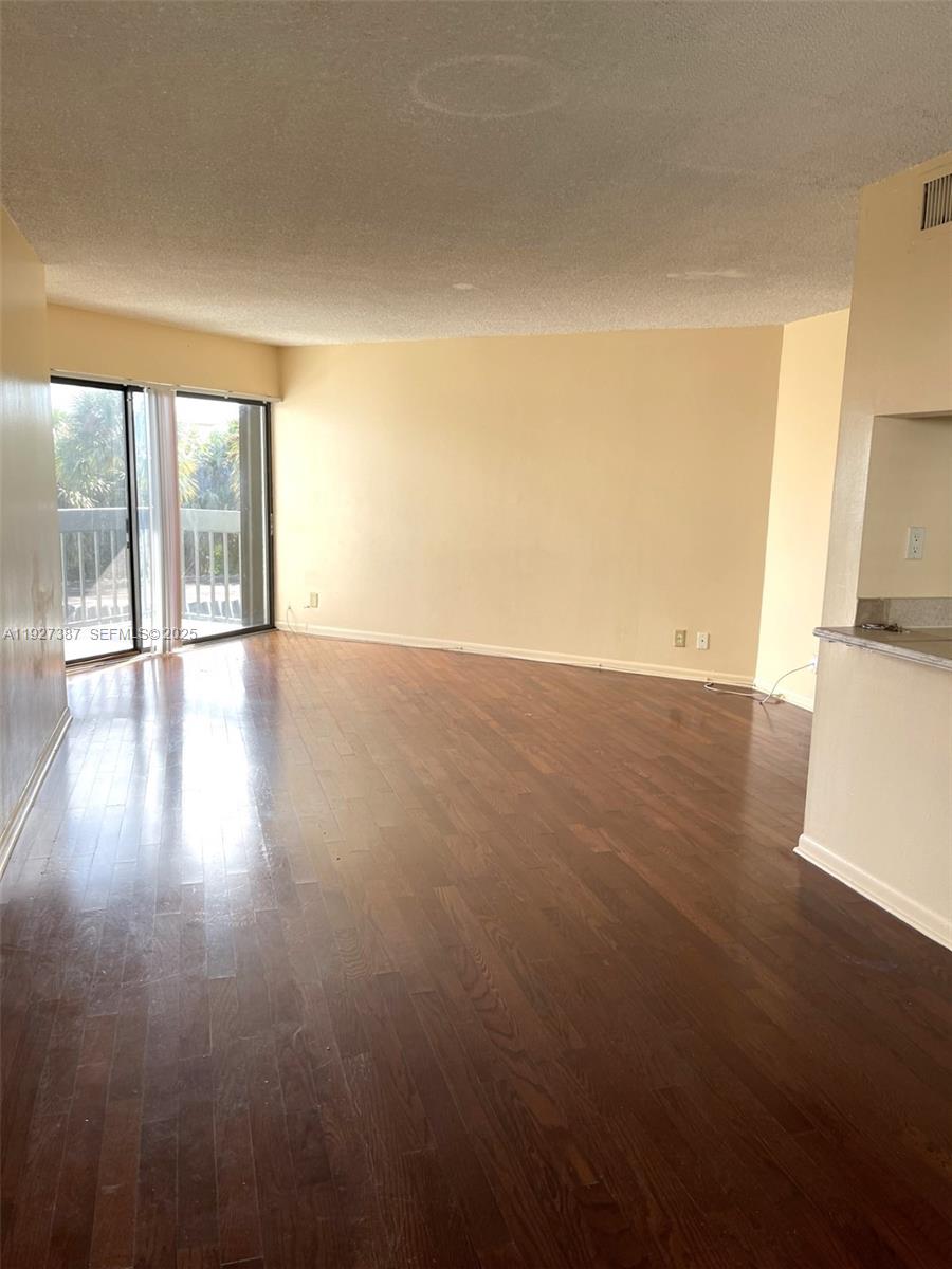 1720 North Congress Avenue, Unit 310 West Palm Beach, FL 33401 - Photo 6 of 18 an empty room with wooden floor and windows