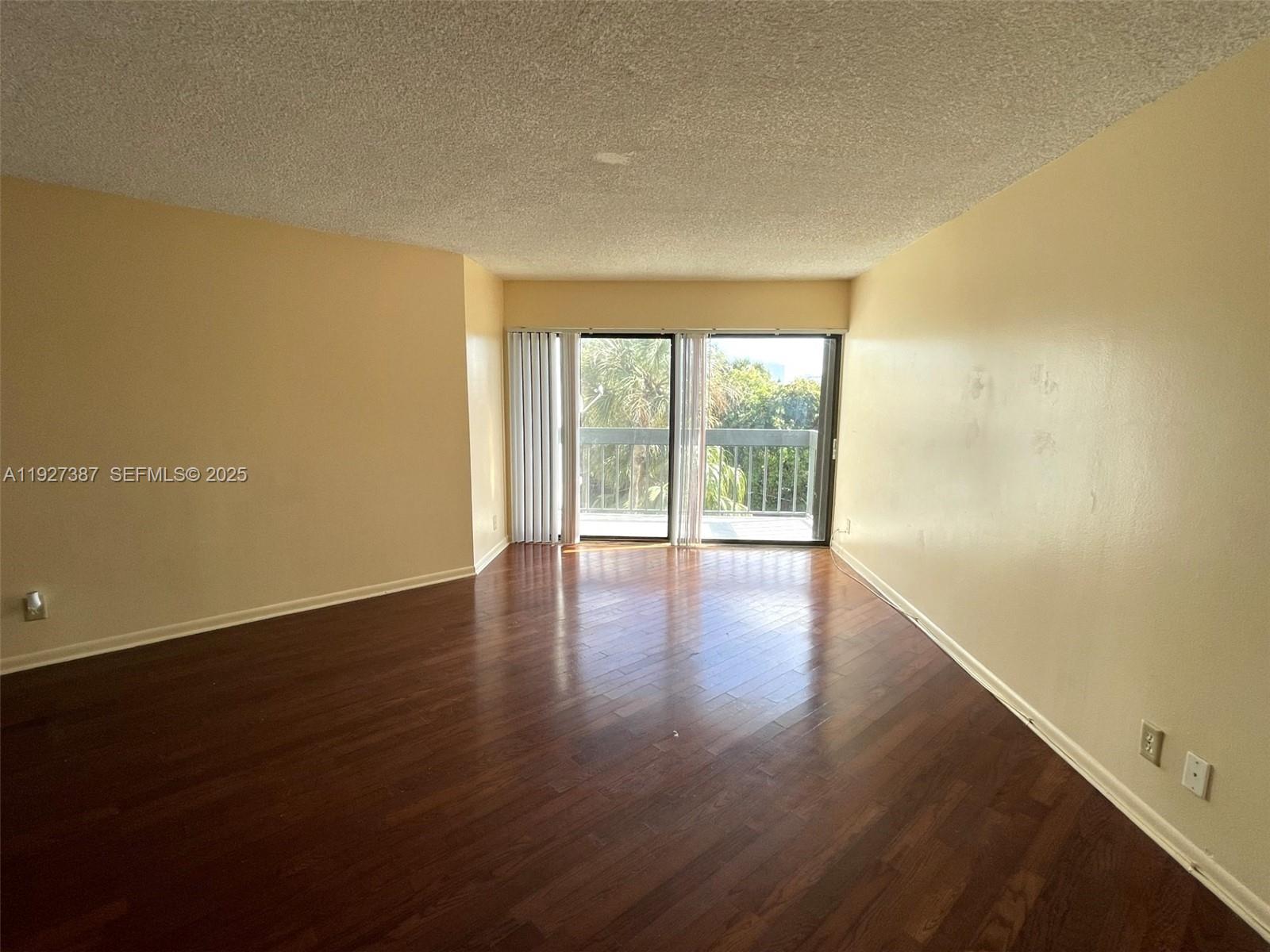 1720 North Congress Avenue, Unit 310 West Palm Beach, FL 33401 - Photo 7 of 18 a view of an empty room with wooden floor and a window