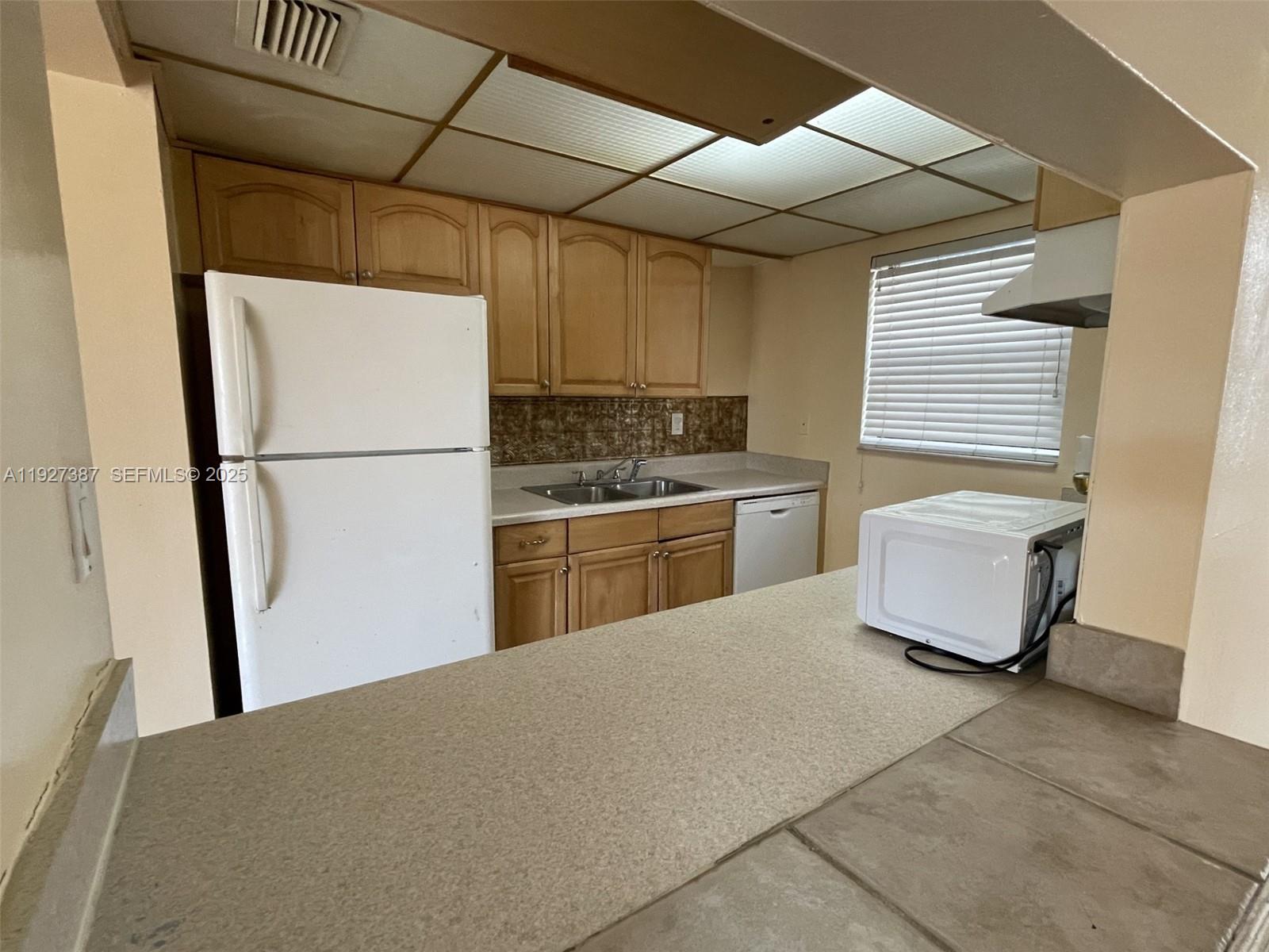1720 North Congress Avenue, Unit 310 West Palm Beach, FL 33401 - Photo 10 of 18 a kitchen with stainless steel appliances granite countertop a refrigerator a sink a stove and white cabinets