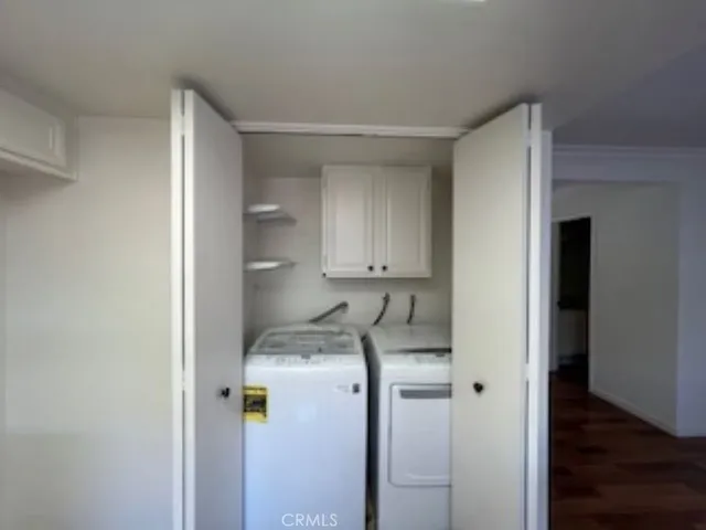 a utility room with cabinets washer and dryer