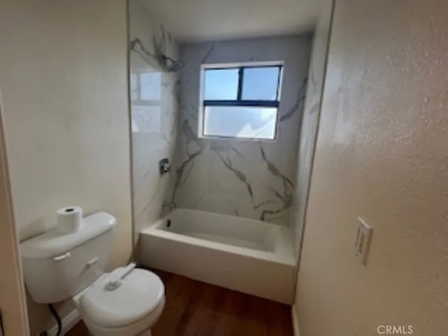 a white toilet sitting next to a bath tub