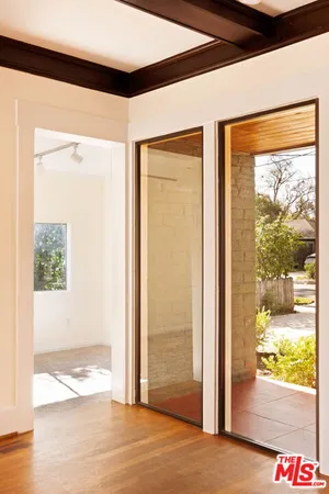 a view of a hallway with wooden floor and a dining room