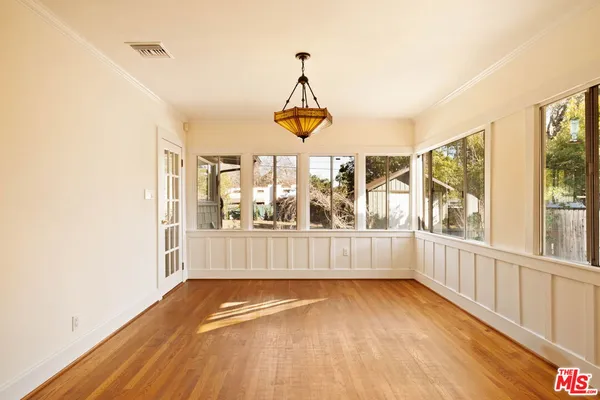 a view of empty room with wooden floor and fan