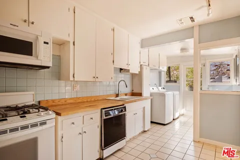 a kitchen with stainless steel appliances a stove a sink and a microwave