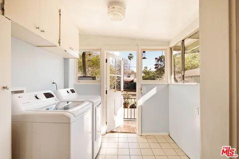 a kitchen with a stove a refrigerator and a view of living room