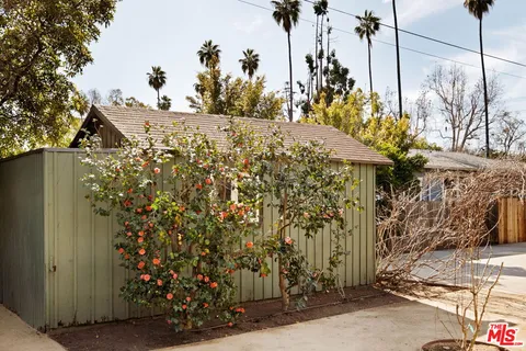 a front view of a house with a yard and tree s