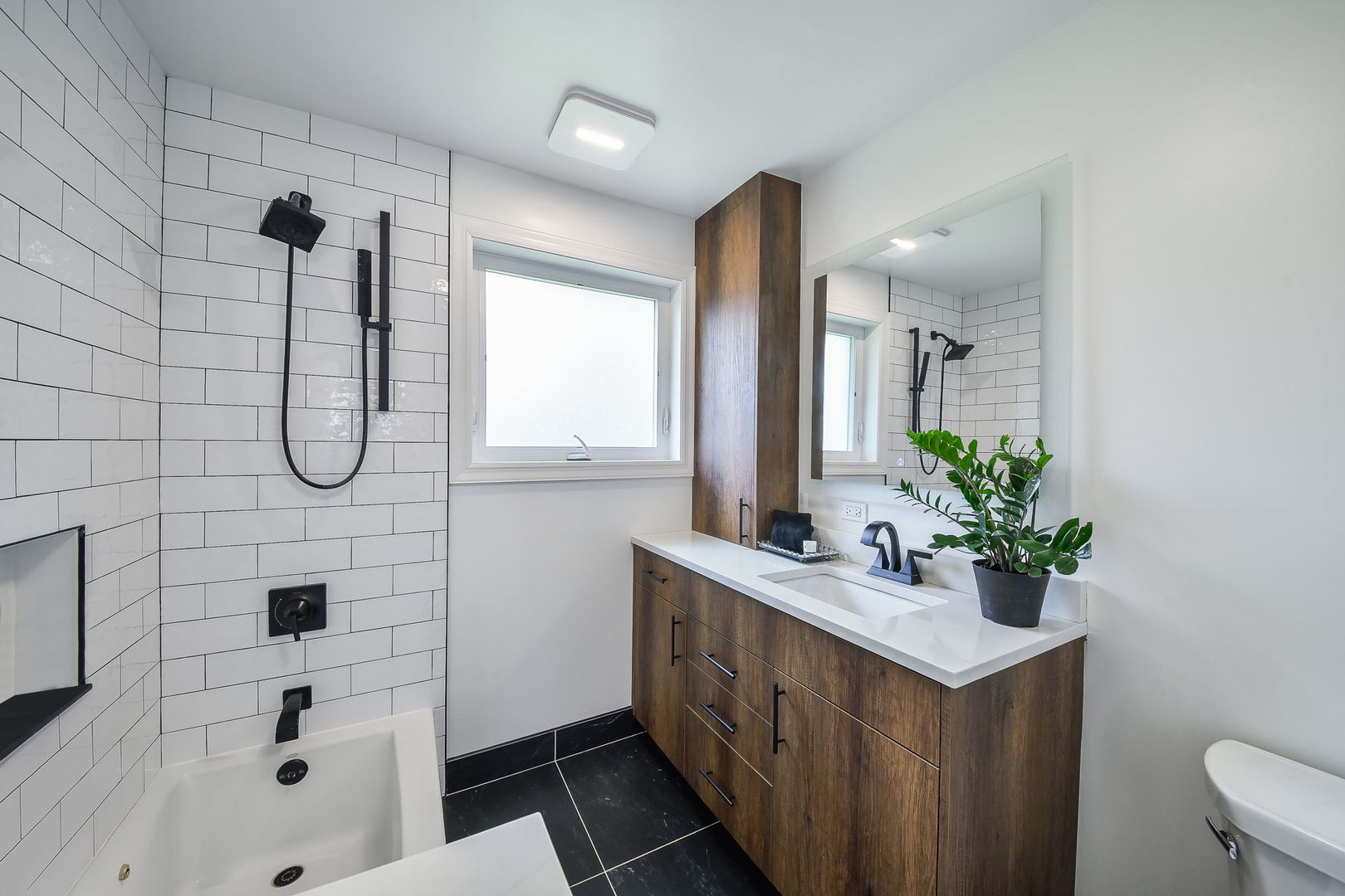 744 Neva Avenue Addison, IL 60101 - Photo 16 of 27 a bathroom with a sink a mirror a potted plant and a shower