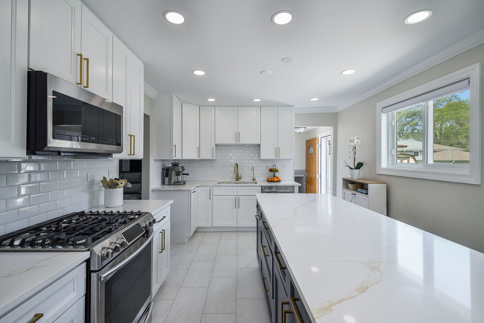 744 Neva Avenue Addison, IL 60101 - Photo 9 of 27 a large kitchen with stainless steel appliances granite countertop a stove a sink dishwasher a refrigerator and white cabinets with wooden floor