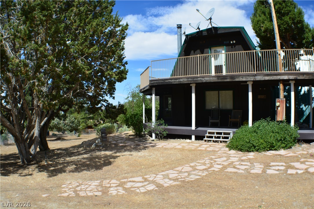 1321 Trout Canyon Road Las Vegas, NV 89124 - Photo 1 of 50 Perched amidst verdant trees, this charming dwelling offers a welcoming facade and a spacious upper-level deck.