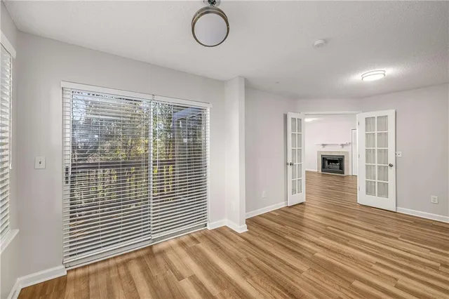 a view of empty room with wooden floor and fireplace