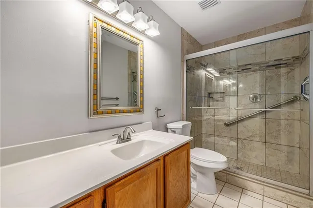 a bathroom with a sink vanity granite toilet and shower