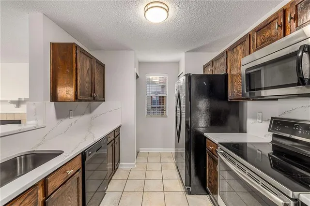 a kitchen with stainless steel appliances granite countertop a refrigerator and a stove top oven