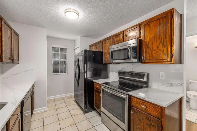 a kitchen with stainless steel appliances granite countertop a stove top oven microwave and refrigerator