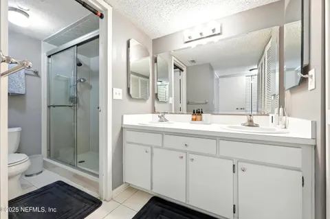 a spacious bathroom with a shower sink and mirror