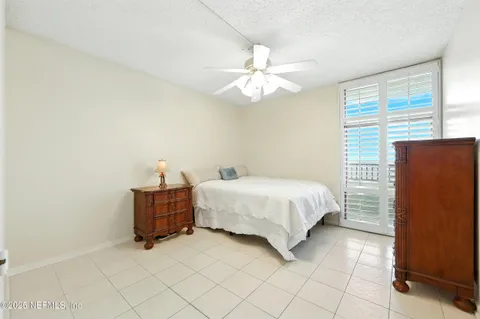 a spacious bedroom with a bed and a chandelier