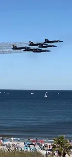 a front view of a building with streets and trees