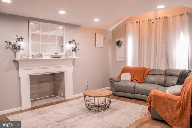 a living room with furniture a fireplace and a large window