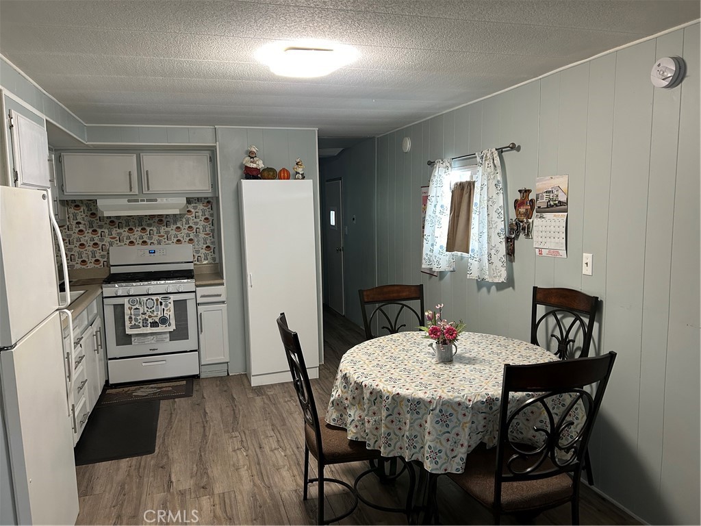 3734 Pacific Street, Unit 40 Highland, CA 92346 - Photo 7 of 35 a kitchen with stainless steel appliances kitchen island granite countertop a dining table chairs and a refrigerator