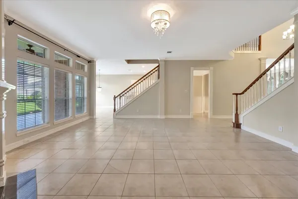 a bedroom with a bed couch and a large window with wooden floor
