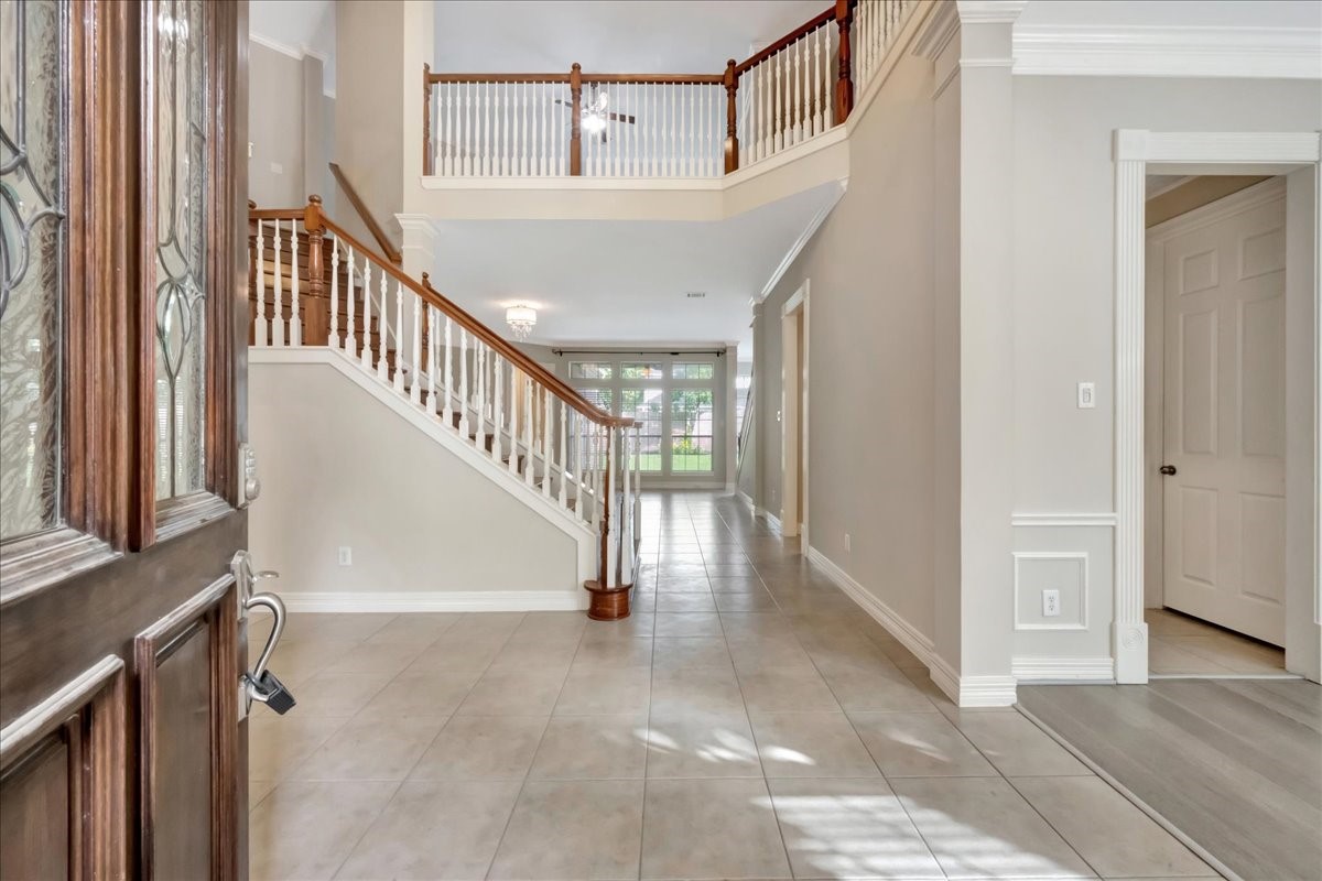 15511 Turtle Oak Court Houston, TX 77059 - Photo 4 of 50 a view of staircase with lots of frames on wall and a window