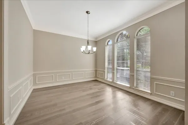 a view of a room with wooden floor fan and windows