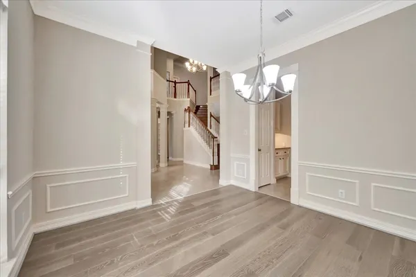 a view of a livingroom with wooden floor and a chandelier