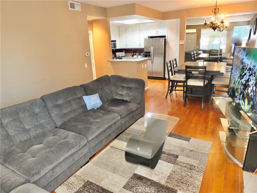 19431 Rue De Valore, Unit 19B Lake Forest, CA 92610 - Photo 6 of 24 a living room with couches and kitchen view with wooden floor