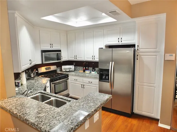 a kitchen with granite countertop a refrigerator and a sink