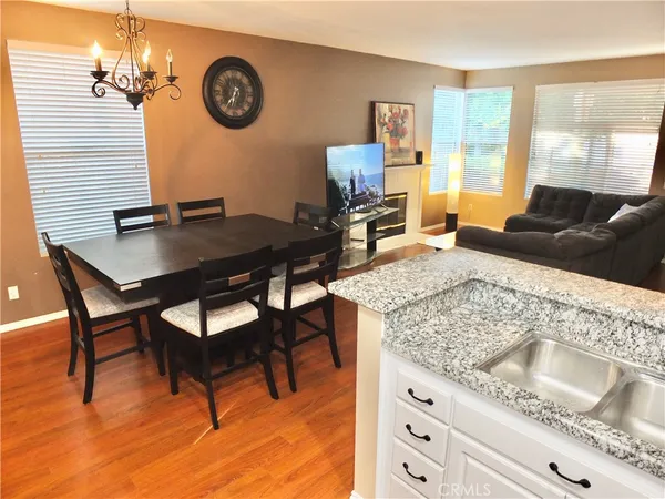 a kitchen with stainless steel appliances kitchen island granite countertop a table chairs refrigerator and microwave