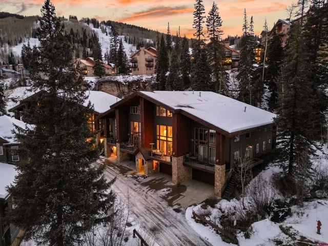 a view of a house with wooden fence next to a yard