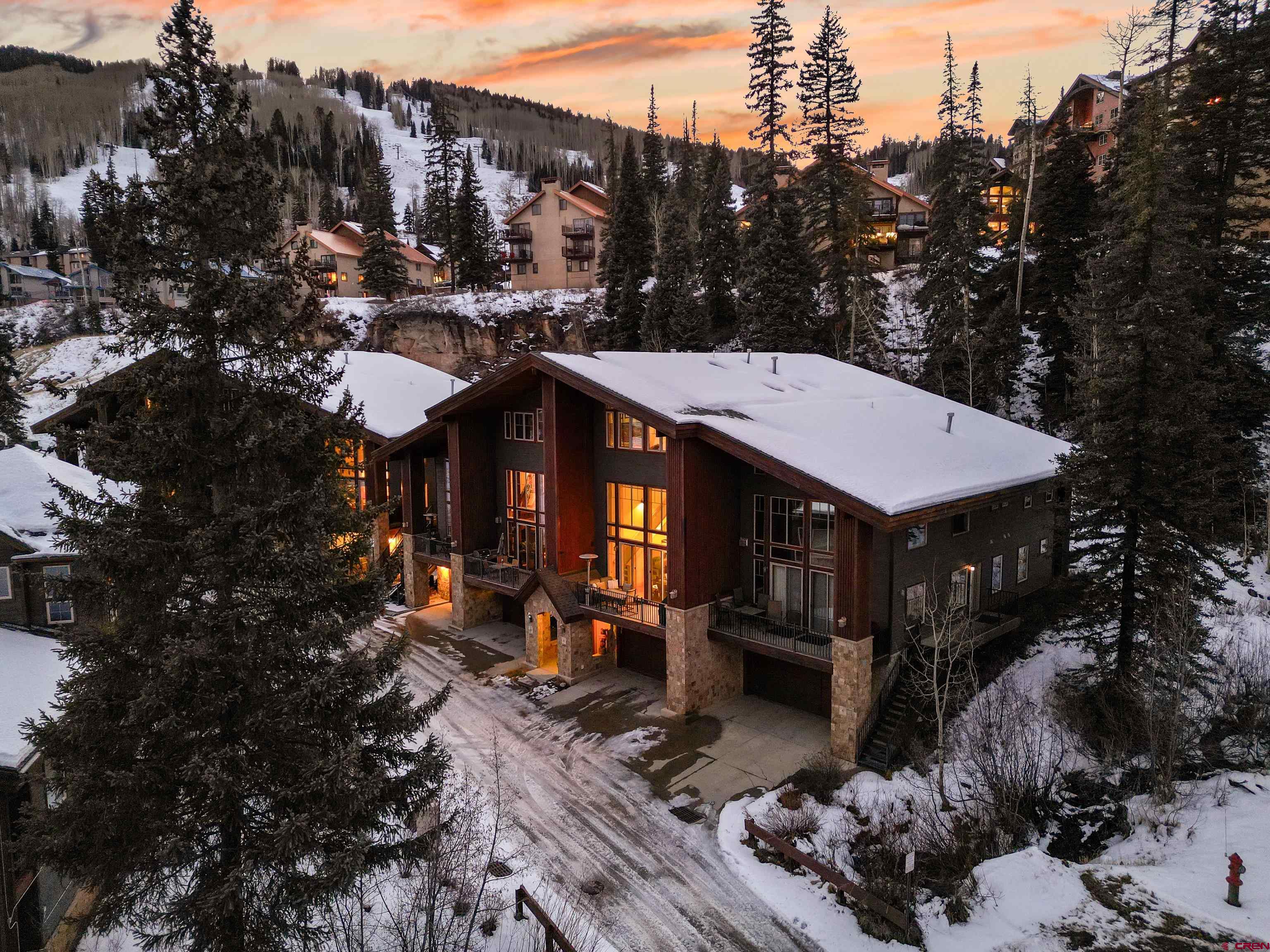a view of a house with wooden fence next to a yard