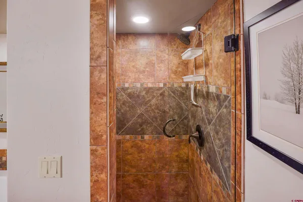 a bathroom with a granite countertop toilet sink a mirror and shower curtain