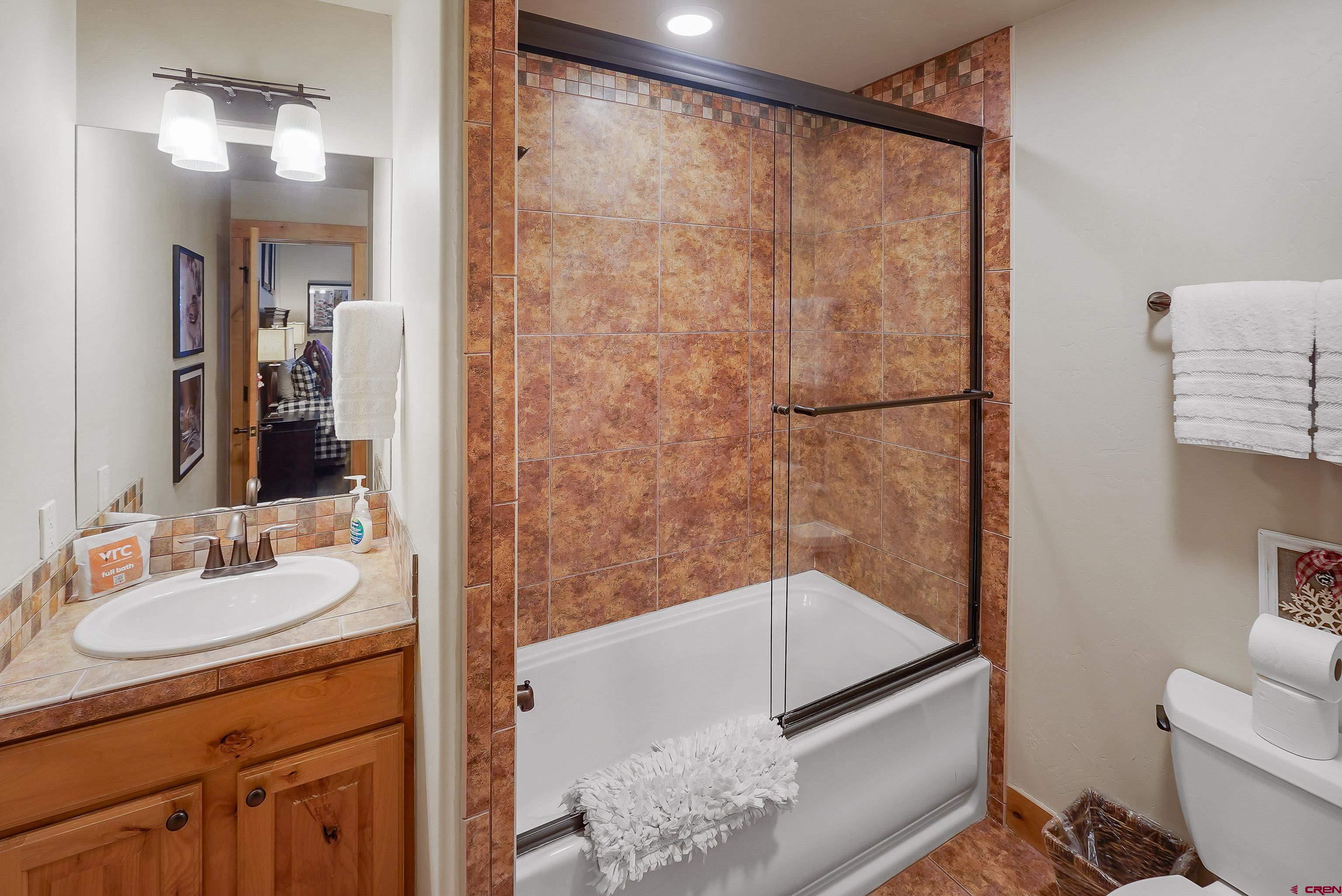 8 Summer Solstice Street Durango, CO 81301 - Photo 18 of 45 a bathroom with a shower sink and mirror