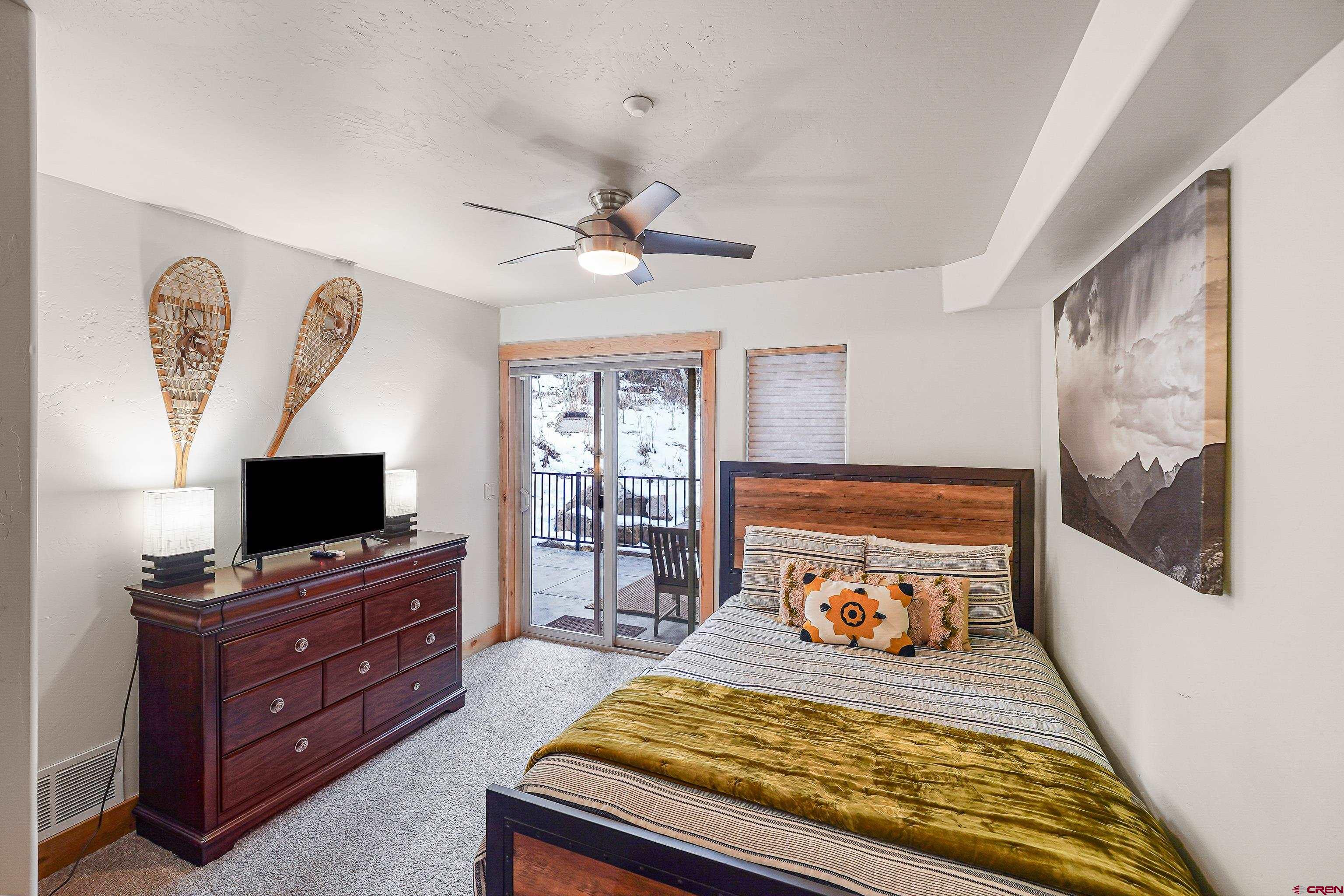 8 Summer Solstice Street Durango, CO 81301 - Photo 23 of 45 a bedroom with a bed and a flat tv screen on a dresser