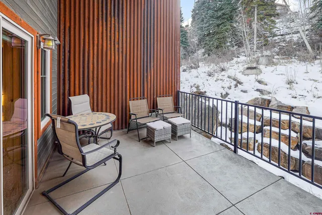 a balcony with chairs and with potted plants
