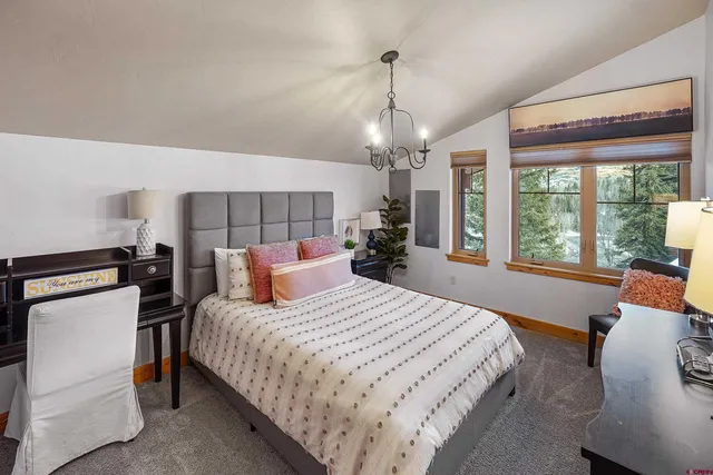 a bedroom with a bed and a chandelier