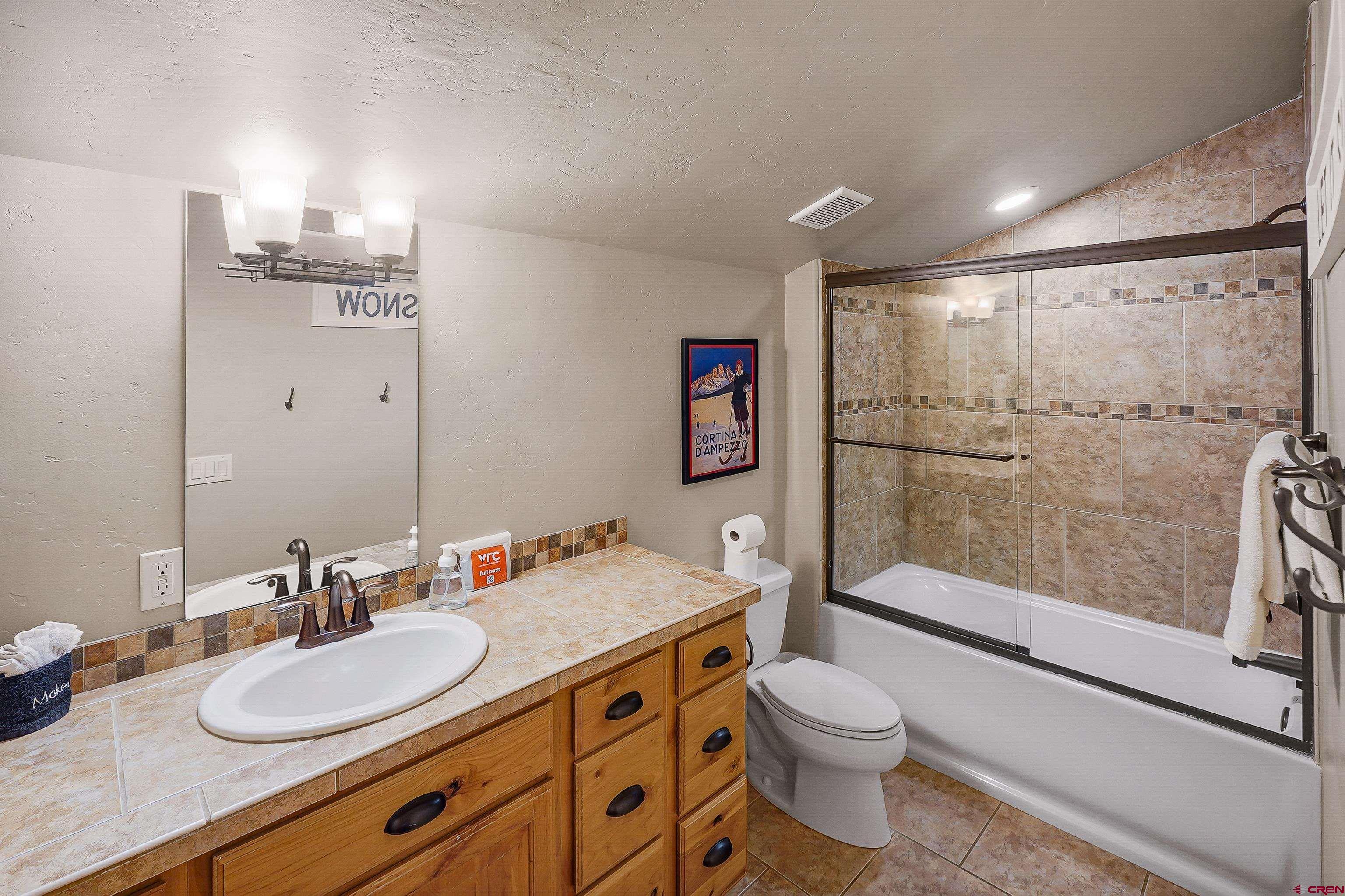 8 Summer Solstice Street Durango, CO 81301 - Photo 29 of 45 a bathroom with a granite countertop sink toilet a mirror and shower