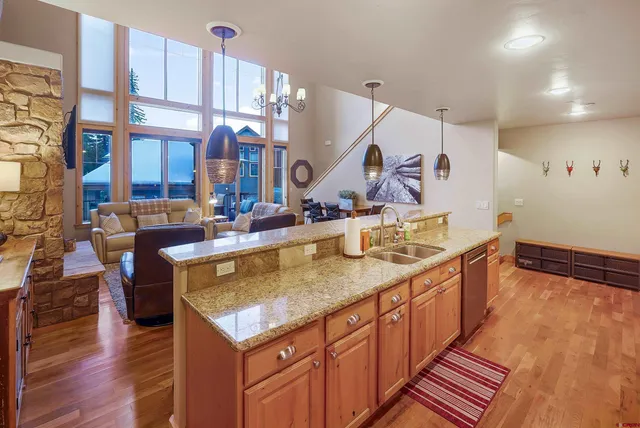 a kitchen with kitchen island granite countertop a stove refrigerator and sink