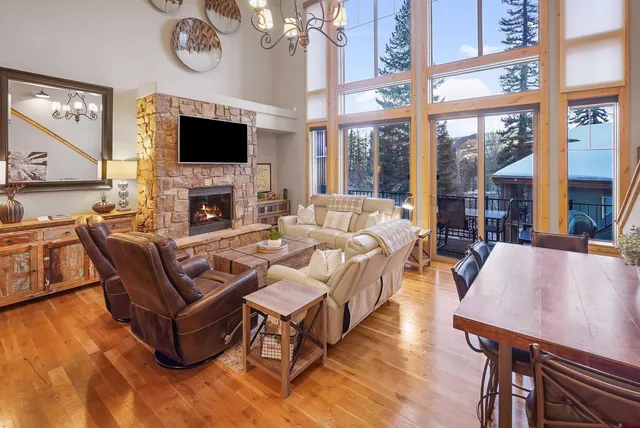 a living room with furniture a chandelier and a dining table