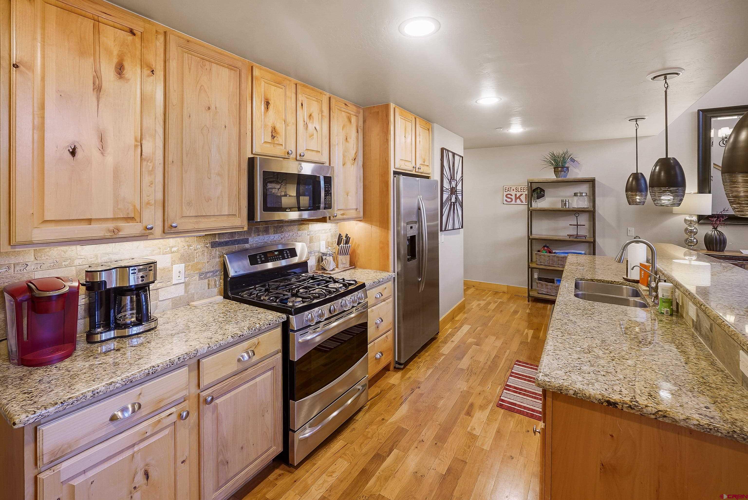 8 Summer Solstice Street Durango, CO 81301 - Photo 9 of 45 a kitchen with kitchen island granite countertop a stove refrigerator and sink