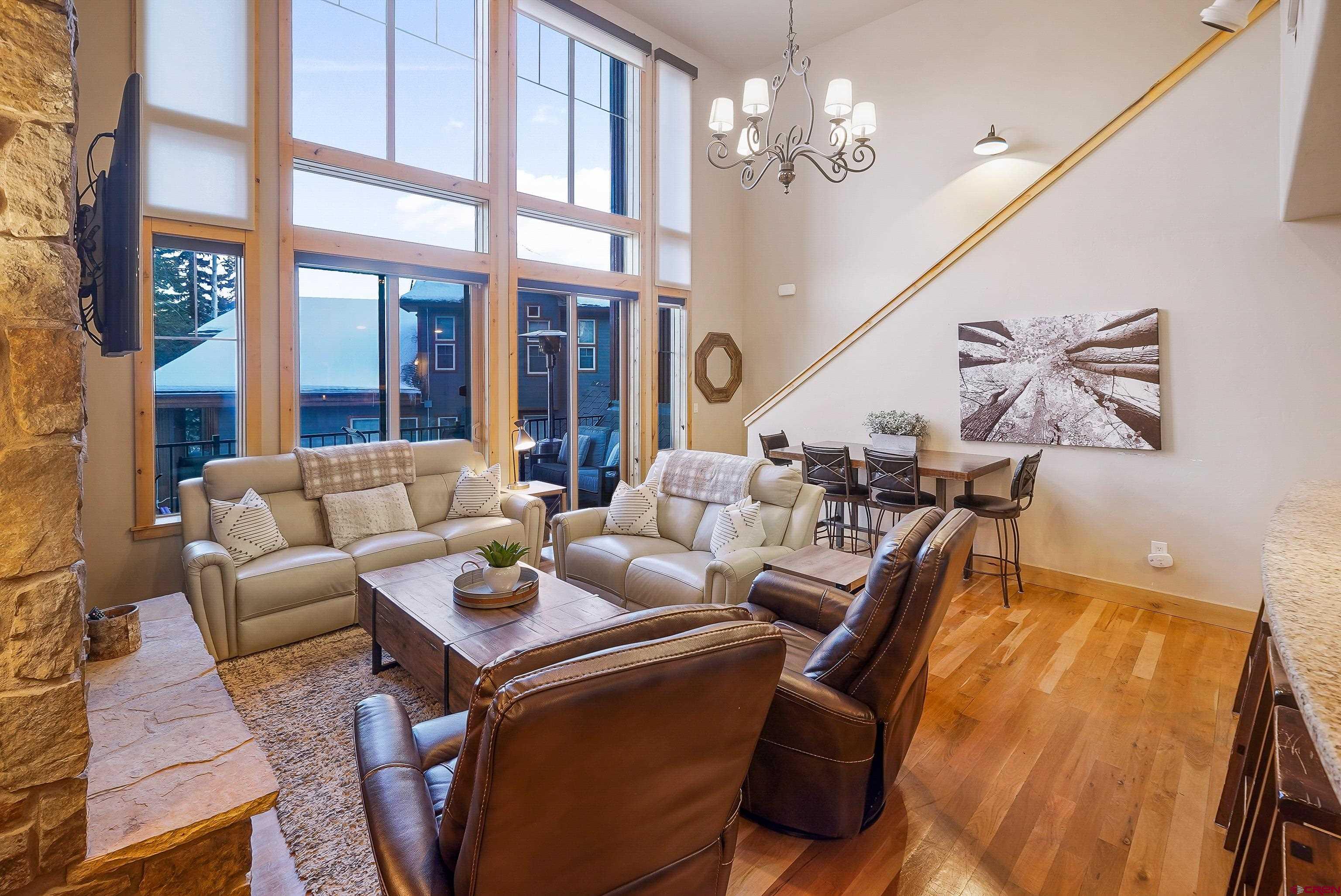 8 Summer Solstice Street Durango, CO 81301 - Photo 10 of 45 a living room with furniture a chandelier and a dining table