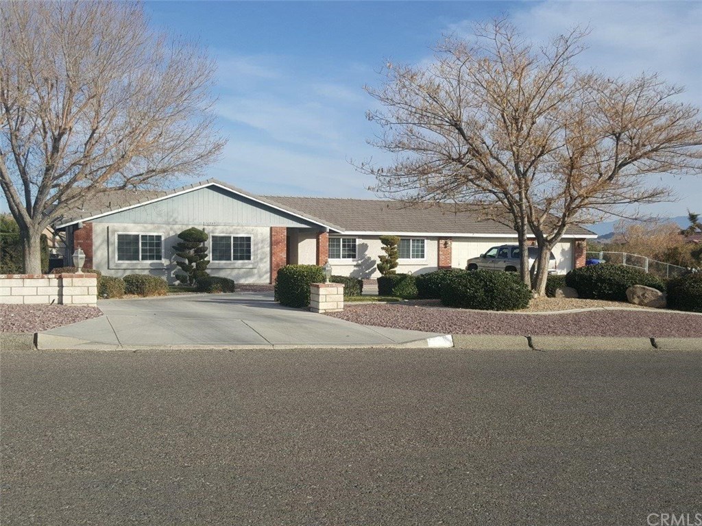 a front view of a building with large trees