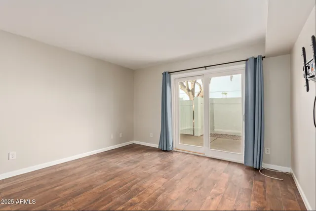 an empty room with wooden floor and sliding door